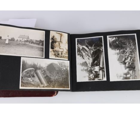 An album of photographs including a series of views depicting a traction engine being uprighted, a WWI period sketchbook with