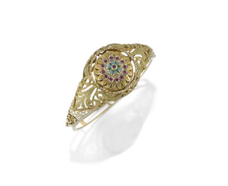 BRACCIALE RIGIDO CON OROLOGIO MONVIS, 1970 CIRCA in oro giallo a scalare lavorato a traforo con centro in rubini e turchesi c