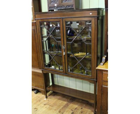 An Edwardian inlaid mahogany vitrine, with a pair of astragal glazed doors, raised on square section tapering legs, joined by