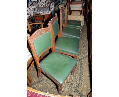 A set of four Victorian Oak framed Dining Chairs having carved and shaped top rail in finial topped supports, green leather p