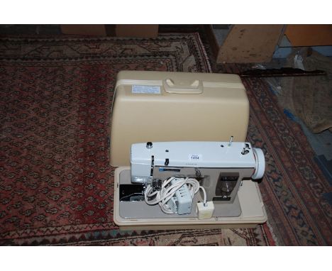 A New Home electric cased Sewing Machine, model 535, with manual enclosed.