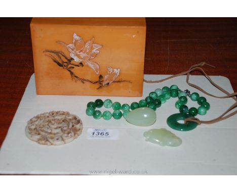 Five pieces of Jade including a string of dark green beads, egg shaped piece, fish, disc and a celadon roundel with dragon ce