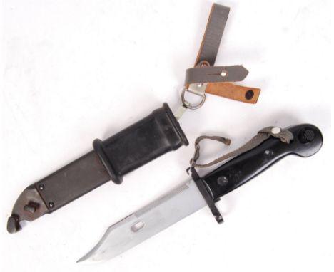 An original AK47 rifle bayonet and scabbard. The bayonet with serrated edge to one side and orignal canvas strapping. The bay