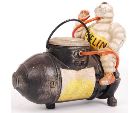 A 20th century vintage style advertising Michelin Tyres mascot 'The Michelin Man,' seated atop / riding an air compressor orn