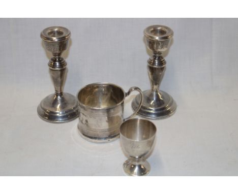 A pair of silver tapered candlesticks, Birmingham marks 5" high; a small silver christening tankard and silver egg cup (4) 