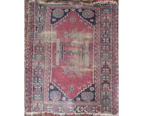 An Eastern hand knotted wool rug with geometric decoration on red ground 47" x 39" 