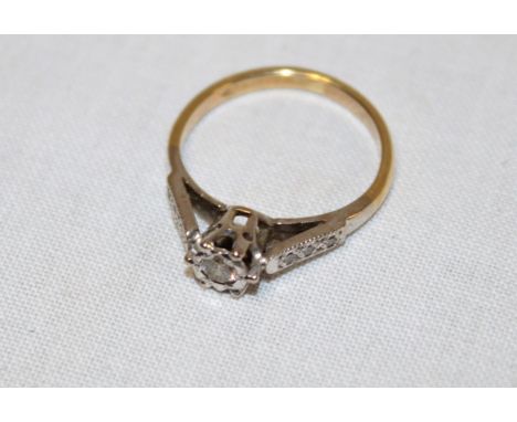 An 18ct gold engagement ring with central diamond flanked by diamond chips 