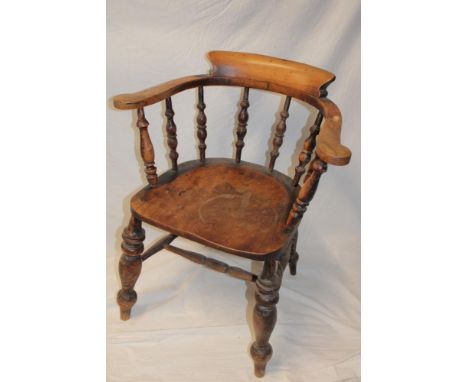 A 19th Century beech and elm Captains style armchair with spindle back and shaped seat on turned legs 