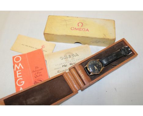 A gentlemans 9ct gold wristwatch by Omega with black circular dial and leather strap, original box with paperwork