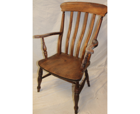 A 19th Century elm and beech lath-back kitchen carver armchair with shaped seat on turned legs 