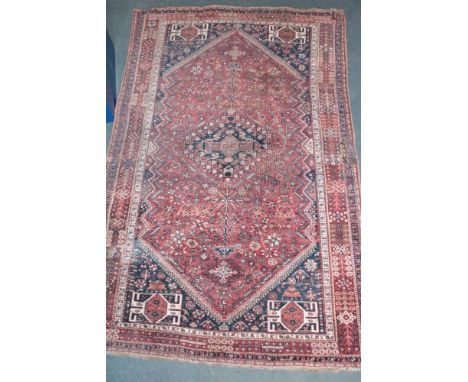 An Eastern hand-knotted wool rug with geometric decoration on red and blue ground, 98" x 61" 