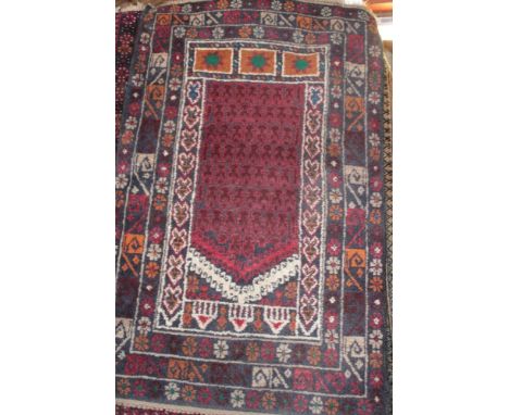 An Eastern wool prayer rug with geometric decoration on red and blue ground, 56" x 36"