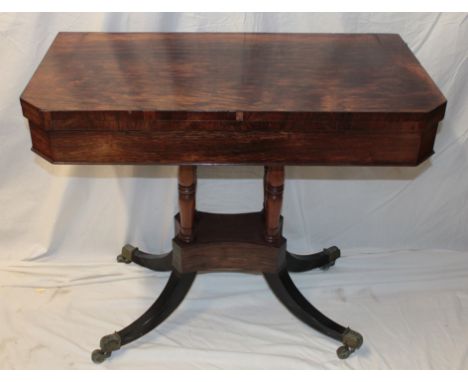 A 19th century rosewood rectangular turn-over-top card table with baize lined playing surface on turned supports and scroll l