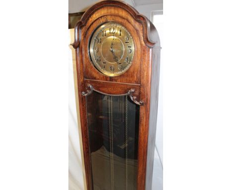 A 1920's/30's grandfather clock with brass circular dial in oak glazed arched traditional case