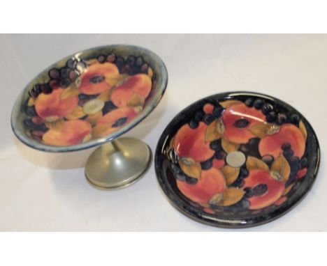 A Moorcroft pottery circular comport with pomegranate decoration and silver plated stand together with one other matching pom