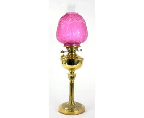 AN EARLY 20TH CENTURY BRASS OIL LAMP WITH YOUNG'S BURNER AND MOULDED CRANBERRY GLASS SHADE, 61CM H EXCLUDING CHIMNEY