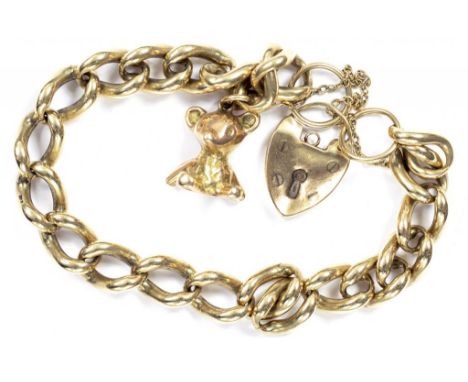 A 9CT GOLD CURB BRACELET WITH PADLOCK AND BEAR CHARM, 59G