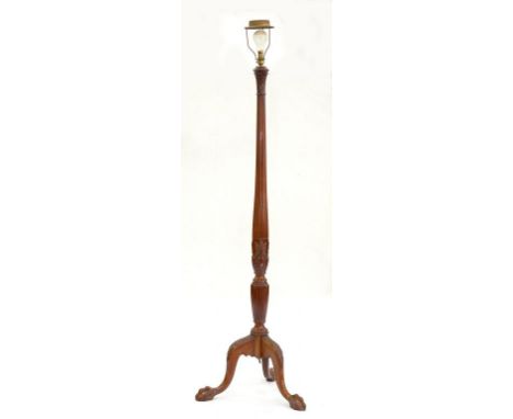 A CARVED MAHOGANY STANDARD LAMP ON CLAW AND BALL FEET