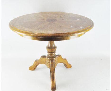 A contemporary circular wooden coffee table with central hexagonal inlaid motif, on a shaped tripod support, height 60cm, dia