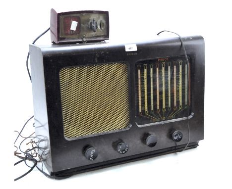 A vintage Philco radio modified to include a slot payment device, the frontal speaker above four dials, in a bakelite case, w