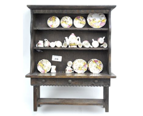 An oak miniature kitchen dresser and a Carmarthen bone china miniature part tea service, transfer printed in the 19th century