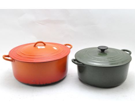 Two large enamel kitchen lidded pots in orange and dark green, largest in orange, diameter circa 34cm, the smaller in green b