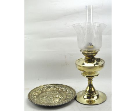 Brass oil lamp and a brass charger, the lamp with original glass shade and funnel, the charger depicting a ship at sea