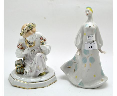 Two Russian ceramic figures, both modelled as women in traditional costume with gilt details, height 24.5cm