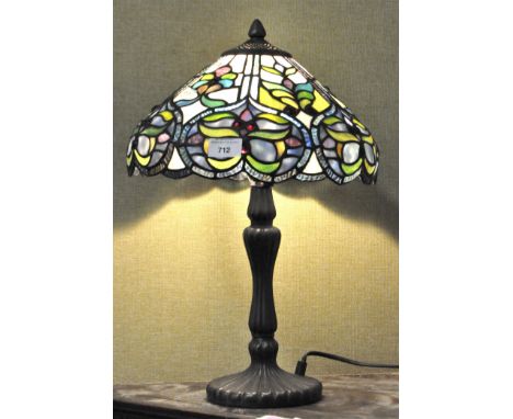 A Tiffany style table lamp, the glass shade featuring shades of blue and green, supported on a cast metal base, height 46cm