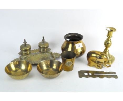 A selection of brassware, including an inkwell decorated with scrolling motifs, a paperweight modelled as an elephant, a beak