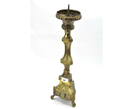 A late 19th/early 20th century brass candlestick, raised upon three lion paw feet, 48cm high