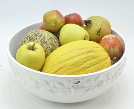 A white glazed ceramic bowl of artificial wood and ceramic fruit, the bowl with a relief band of fruits on a vine, height 11c