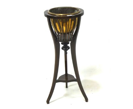 An oak jardiniere stand with brass liner enclosed in a spindle frame, above a splayed tripod support with lower shelf, height