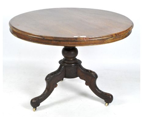 A Victorian mahogany tilt top round table on turned support and carved tripod cabriole legs with casters, height 74cm, diamet