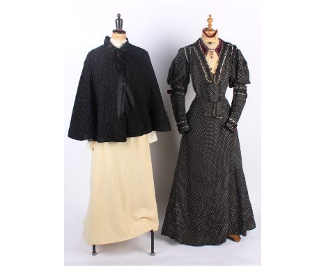 A French black and white silk costume circa 1900; with a black textured wool cape, cream wool blouse, full-length cream wool 