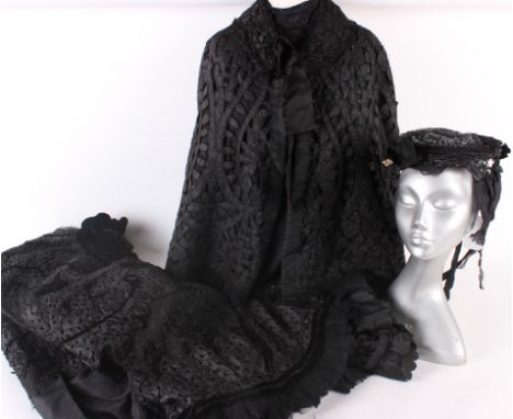 Ladies costume dating from the late 19th and early 20th century; comprising: a black silk, lace edged shoulder cape, a bonnet