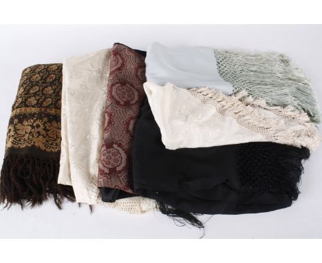 A 19th century woven wool shawl; together with a black satin fringed shawl with woven Art Deco decoration at each end, a pale