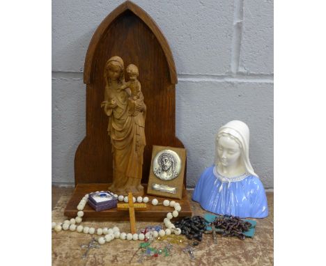 A wooden bracket shelf with a carved figure of the Virgin Mary, a Belgian bust, four rosaries, a plaque of Jesus and an ename