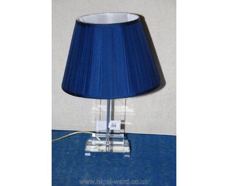 A contemporary glass table lamp with blue shade.