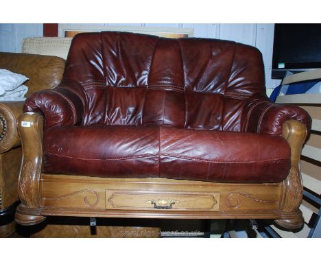 A two seat leather sofa on a wooden frame with drawer to base.