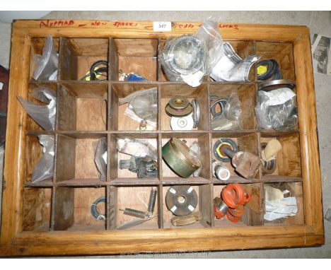 A pigeon-hole storage shelf unit containing a good quantity of mixed new spare parts including roller and ball bearing races,