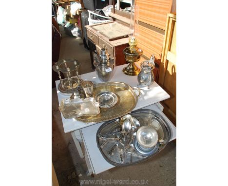 Box of metal ware including an oil lamp, cocktail set, plated trays etc.