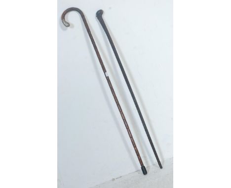 An antique 20th century walking stick having a hallmarked silver cap to the handle, together with another example with root b