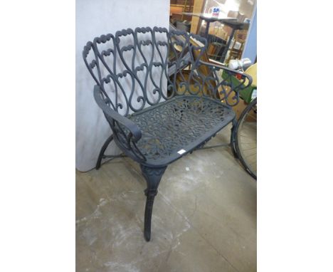 A cast iron garden table, two chairs and  bench 