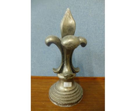An aluminium fleur de lys finial