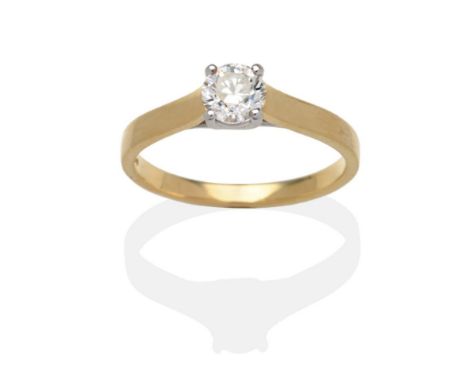 An 18 Carat Gold Diamond Solitaire Ring, a round brilliant cut diamond in a white claw setting, on a yellow plain polished sh