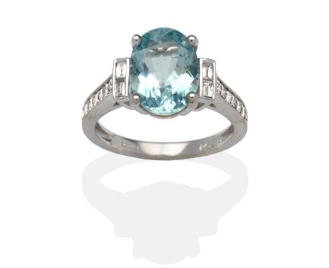 An 18 Carat White Gold Aquamarine and Diamond Cluster Ring, an oval cut aquamarine in a white claw setting spaced each side b