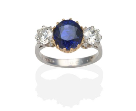 A Platinum Sapphire and Diamond Three Stone Ring, a round cut sapphire in a yellow claw setting between old cut diamonds in w