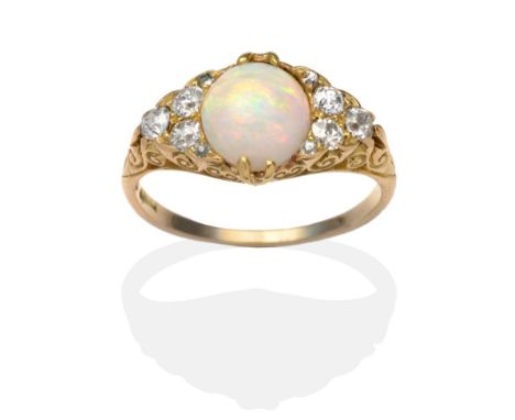 An Opal and Diamond Ring, an oval opal between old cut diamond accents in a carved yellow setting, on a plain polished shank,