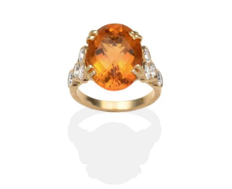 A French Citrine and Diamond Ring, an oval checkerboard cut citrine in a yellow double claw setting, to shoulders each set wi